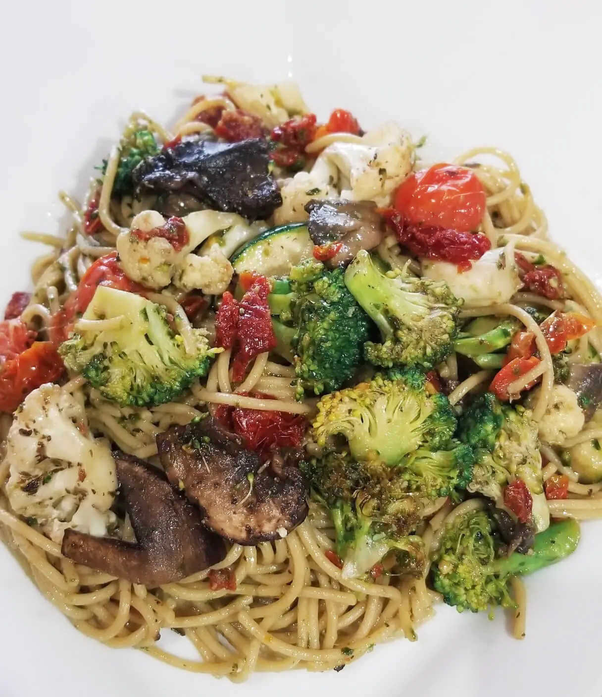 A dish of pasta adorned with broccoli and mushrooms, creating a delectable and nutritious meal